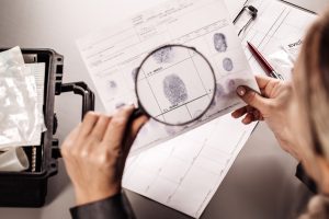 Criminology expert looking through a magnifying glass at a fingerprint