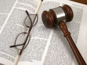 Glasses and gavel on top of open law book